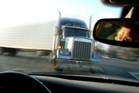 view through a vehicle windshield as a truck is about to crash into them